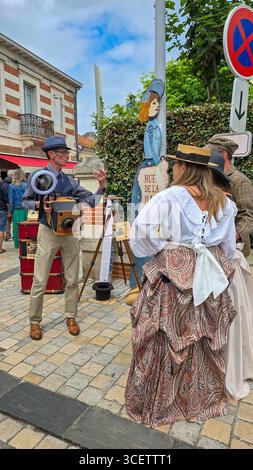Ein Street Retro Fotograf fotografiert eine Familie in Kostümen von Belle Epoque auf dem Festival Soulac 1900. Juni 2025. Soulac-sur-Mer, Frankreich. Stockfoto