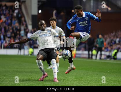Rangers Jayden Meghoma und Club Brugge Carlos scheitern um den Ball während der UEFA Champions League, Play-off, im ersten Legspiel im Ibrox Stadium, Glasgow. Bilddatum: Dienstag, 19. August 2025. Stockfoto