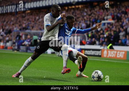 Rangers Jayden Meghoma und Club Brugge Carlos scheitern um den Ball während der UEFA Champions League, Play-off, im ersten Legspiel im Ibrox Stadium, Glasgow. Bilddatum: Dienstag, 19. August 2025. Stockfoto