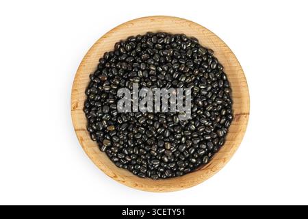 Schwarze Bohne oder Urad dal, schwarzes Gramm, vigna mungo in Holzschale isoliert auf weißem Hintergrund. Draufsicht. Flache Lagen. Stockfoto