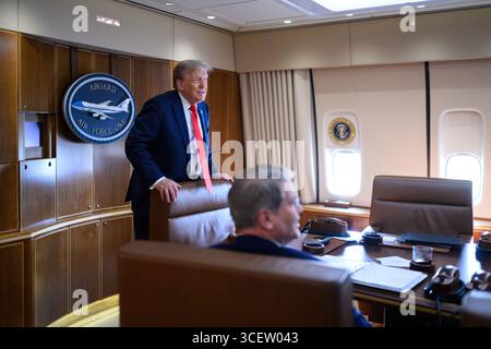 Präsident Donald Trump spricht mit Mitarbeitern an Bord der Air Force One am Freitag, den 15. August 2025, auf dem Weg zur Joint Base Elmendorf Richardson, Alaska, zu einem Treffen mit dem russischen Präsidenten Wladimir Putin. (Offizielles Foto des Weißen Hauses von Daniel Torok) Stockfoto