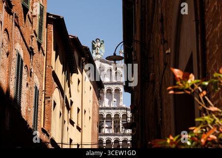 Ein Blick auf San Michele in der Kirche Foro durch die enge Straßenschlucht von Lucca, Italien Stockfoto