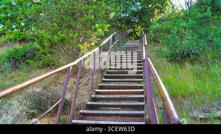 Treppenaufgang mit Geländer auf einer steilen Klippe auf der Insel Usedom, die vom Strand zum obersten Küstenweg in Norddeutschland führt. Stockfoto