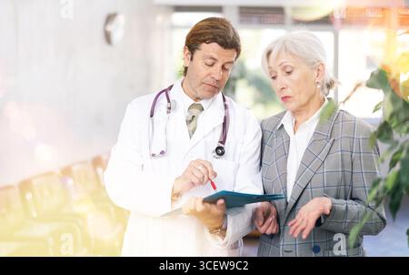 Aufmerksamer Arzt verschreibt Tests an Patienten der Klinik, um den Gesundheitszustand zu überprüfen Stockfoto