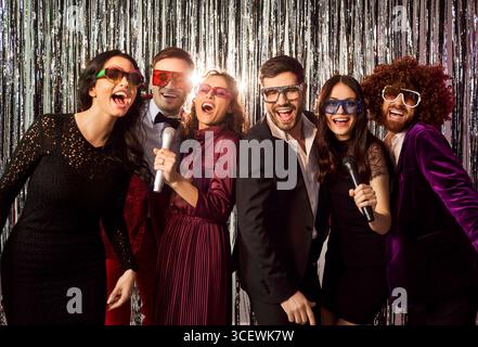 Glückliche Freunde Singen Karaoke Auf Der Nachtclub-Party Stockfoto