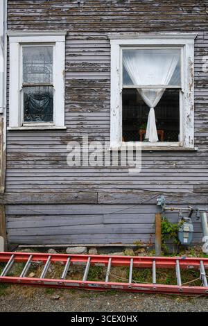 Fenster in einem verwitterten Holzhaus mit abblätternder Farbe in Vancouver, BC. Stockfoto