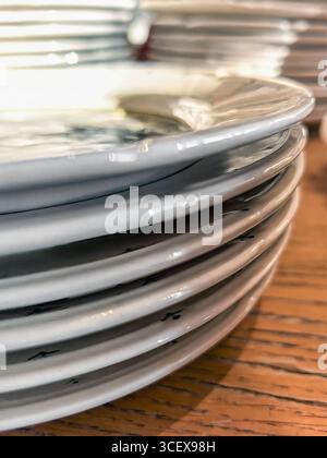 Stapel sauberer weißer Platten auf Holztischplatte Stockfoto
