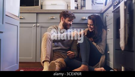 Lächeln Sie, paaren Sie und essen Sie Eis auf dem Boden mit Liebe, teilen Sie sich Dessert und verbinden Sie sich miteinander. Glücklich, Leute und entspannen Sie sich mit süßen Leckereien für romantische Stockfoto