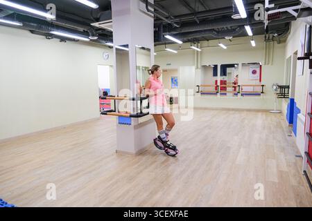 moskau, russi, 05.03.2025 Frau in kango springt auf eine Ballettbarre in einem Tanzstudio. Fitness- und Energiesport. Aktiver Lifestyle und Workout im Fitnessstudio Stockfoto