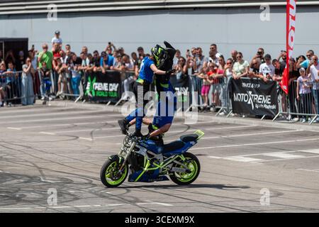Stuntfahrer Dejan Spoljar mit der Crew auf dem Moto fest, die verschiedene Akrobatik macht Stockfoto