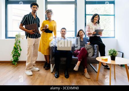 Multi-ethnische Geschäftsteams, die sich in modernen Büros mit Laptop und Tablet präsentieren und Teamwork, Zusammenarbeit und Erfolg in Startup-Umgebungen repräsentieren Stockfoto