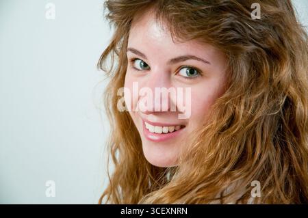 Porträt der jungen Frau lächelt und schaut in die Kamera. Schließen Sie die Ansicht. Stockfoto