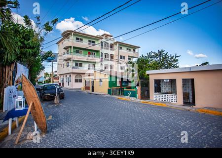 Bayahibe, dominikanische republik 19. august 2025: Eine ruhige Straßenszene mit Kopfsteinpflaster, die die farbenfrohen Gebäude und das lokale Leben in bayahibe, dominikanische republik, zeigt Stockfoto