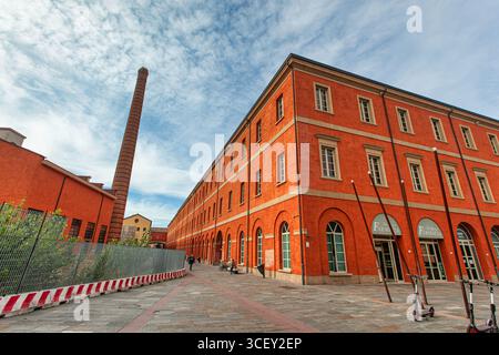 Modena, italien 20. august 2025: Revitalisierte Backsteinarchitektur und ein ikonischer Kamin heben das historische manifattura tabacchi in modena hervor Stockfoto