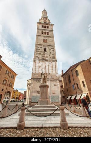 Modena, italien 20. august 2025: Der ghirlandina-Turm erhebt sich majestätisch über der piazza grande mit der Statue des ciro menotti in modena, italien Stockfoto