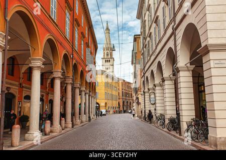 Modena, italien 20. august 2025: Der ghirlandina-Turm dominiert das Stadtbild von modena, italien, umgeben von malerischen Gebäuden mit Bögen Stockfoto