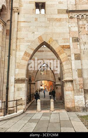 Modena, italien 20. august 2025: Menschen, die unter den Bögen der Kathedrale von modena spazieren, einem romanischen Meisterwerk in der italienischen emilia-romagna Stockfoto