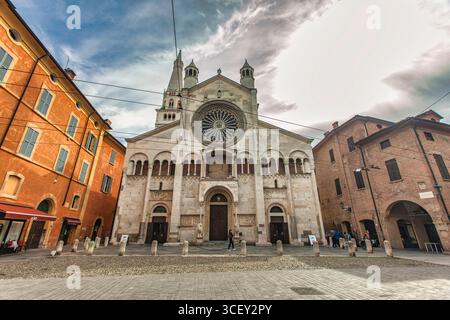 Modena, italien 20. august 2025: Die Kathedrale modena zeigt ihre romanische Architektur auf der piazza grande, modena, emilia-romagna, italien, unter einem bewölkten Himmel Stockfoto