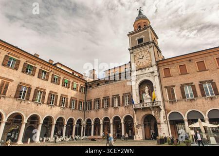 Modena, italien 20. august 2025: Touristen gehen auf der piazza grande mit dem palazzo comunale hoch in modena, italien Stockfoto