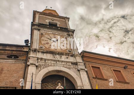Modena, italien 20. august 2025: Uhrenturm mit römischen Ziffern, die die Zeit markieren, in modena, italien, unter bewölktem Himmel Stockfoto