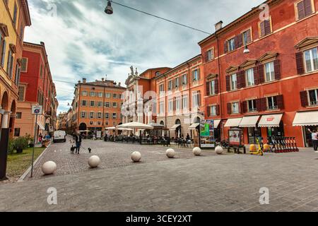 Modena, italien 20. august 2025: Kopfsteinpflasterplatz mit Café und Kirche im historischen Stadtzentrum von modena, italien Stockfoto