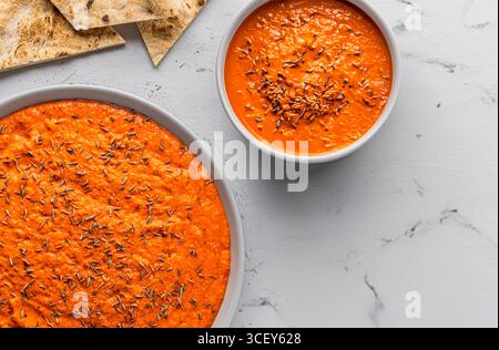Rustikaler Dip mit rotem Pfeffer, serviert mit knusprigem Brot, mediterraner Vorspeise, fotografiert in natürlichem Licht. Kanarische Insel Mojo Picon inspirierte Speisen. Stockfoto