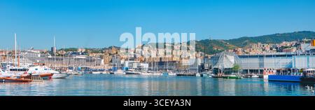 Genua, Italien - 28. Juni 2025: Panoramablick auf Genua Uferpromenade mit großem Kreuzfahrtschiff, farbenfrohen Hügellandgebäuden und reflektierendem Blick auf die Biosfera-Kugel Stockfoto