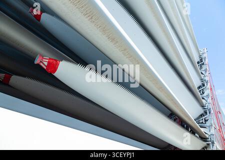 Die Rotorblätter von Windturbinen wurden in speziellen Befestigungselementen auf dem Deck des Schiffes für den Transport auf dem Schiff angekettet. Stockfoto