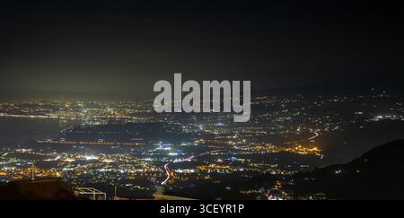Eine ruhige Aussicht, eine glühende Stadt, Lichter erstrecken sich bis in die Nacht von Casstelmona Stockfoto