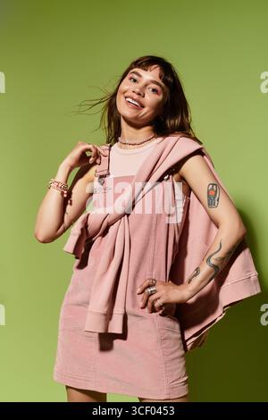 Eine stilvolle junge Frau lächelt selbstbewusst in einer farbenfrohen Umgebung. Stockfoto