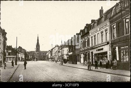 Eine Fotografie, die zwischen 1900 und 1910 aufgenommen wurde, zeigt die Rue de Lille und Eglise Saint-Martin in Croix, Nord, Frankreich. Das Bild fängt den Schnittpunkt von urbanem Leben und religiösen Wahrzeichen ein. Stockfoto