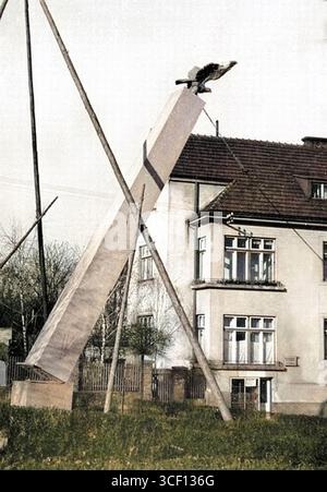 Ein Farbfoto aus dem Herbst 1941 im Protektorat Böhmen und Mähren, das die gewaltsame Entfernung von Sokol-Bewegungssymbolen nach dem Verbot der Organisation dokumentiert. Das Bild zeigt die Zerstörung von Sokol-Symbolen während der deutschen Besatzung. Stockfoto