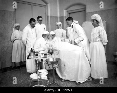 Ein Foto aus dem Jahr 1912, das Chirurgen zeigt, die eine Gehirnoperation am Gemeenteziekenhuis (Stadtkrankenhaus) in den Haag durchführen, wobei mehrere Schwestern während des Eingriffs assistierten. Stockfoto