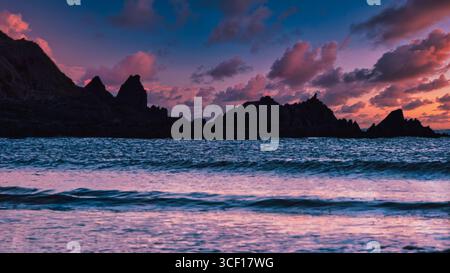 Dramatischer Sonnenuntergang über dem Meer mit Silhouetten von Felsen. Ruhig und friedlich. Stockfoto