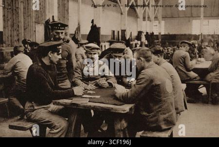 Eine Propagandakarte aus dem Ersten Weltkrieg, die Gruppen deutscher Kriegsgefangener zeigt, die Karten in einem Lager in Southampton, Hampshire, spielen. Das Bild zeigt das tägliche Leben in Gefangenschaft, aufgenommen zwischen 1914 und 1918. Stockfoto