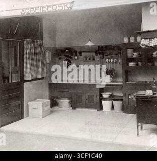Eine einfache Kücheneinrichtung aus einem Musterhaus in Amsterdam aus dem Jahre 1921. Die Küche verfügt über eine Rasentruhe, ein Waschbecken, Eimer, Herd und ein Gestell für Sand, Seife und Limonade. Stockfoto