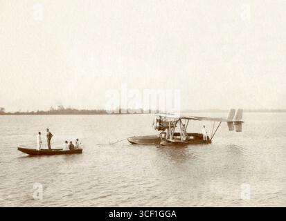 1929 kam Charles Lindbergh (1902–1974) mit einem Flugzeug nach Suriname, das auf einem Boot einen Fluss hinunter flog. Lindbergh steht in einem kleinen Boot vor dem Flugzeug. Die Szene wird in Paramaribo, Suriname, aufgenommen. Stockfoto