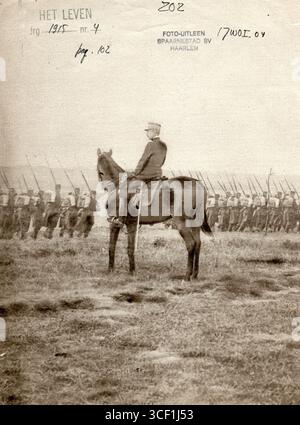 Ein französischer Offizier zu Pferd beobachtet während des Ersten Weltkriegs marschierende Truppen. Die Soldaten tragen Rucksäcke und Gewehre mit Bajonetten. Das Foto wurde 1915 in Frankreich aufgenommen. Stockfoto