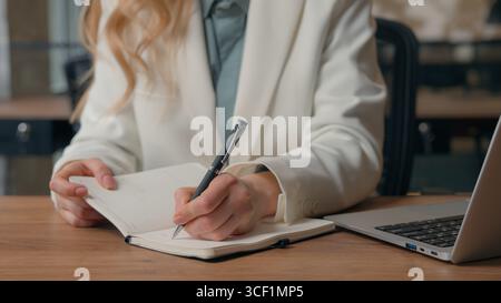 Nahaufnahme unerkennbare kaukasische Frau Geschäftsmädchen weibliche professionelle Geschäftsfrau Facharbeitermanagerin im Büro am Tisch, die Notizen schreibt Stockfoto