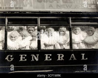 1915 wird eine Gruppe englischer „Pierrettes“ mit Perücken und großen weißen Kragen durch die Fenster eines Busses lachen und Geld für Kriegsverwundete in England während des Ersten Weltkriegs sammeln Stockfoto