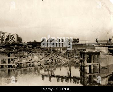 Belgische Soldaten marschieren über eine Brücke über die Schelde, die von den Deutschen zerstört wurde, aber später von den Belgiern im Ersten Weltkrieg im Oktober 1914 repariert wurde. Stockfoto