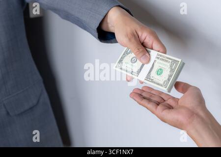 Nahaufnahme symbolischer Aufnahmen von Korruption und Bestechung, die versteckte Hand zeigt, die einen Geldumschlag unter dem Tisch erhält Stockfoto