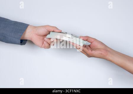 Nahaufnahme symbolischer Aufnahmen von Korruption und Bestechung, die versteckte Hand zeigt, die einen Geldumschlag unter dem Tisch erhält Stockfoto