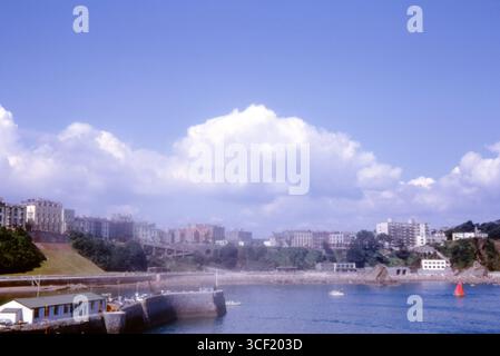 Blick auf Tenby Harbour und Strand, Pembrokeshire, Wales, mit georgianischen Terrassen und Sommeraktivitäten, September 1964. Stockfoto