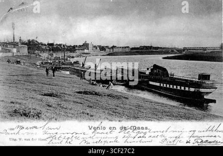 Blick auf den Fluss Maas vom St. Urbanusweg aus im Jahr 1910, mit der St. Nicolaas Kirche, dem Rathausturm, der Maaskade, dem Bontamps Umschlag und der Papierfabrik, der Havenkade, der Molensingel Mühle und der Maas Brücke im Hintergrund. Stockfoto