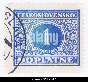 TSCHECHOSLOWAKEI - 1. Februar 1928: 1 Koruna Ultramarin Briefmarke mit abstraktem Kunstwerk mit Denomination, Blumenschmuck und Inschrift „DOPLATNE“ Stockfoto