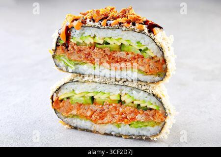 Knuspriges Onigirazu-Sushi-Sandwich mit pikanter Thunfisch-, Gurken- und Avocado-Füllung Stockfoto