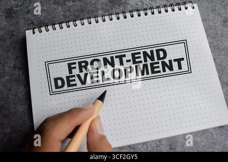 Konzept der Frontend-Entwicklung Schreiben Sie auf Buch isoliert auf Holztisch. Stockfoto