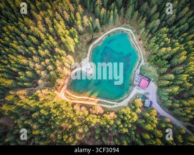 Blick aus der Vogelperspektive auf den Lago Pianozes, einen kleinen alpinen See umgeben von dichtem Nadelwald in der Nähe von Cortina d'Ampezzo, Dolomiten, Provinz Belluno, Region Veneto, Nordosten Italiens Stockfoto