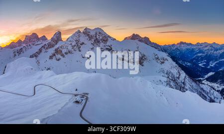 Aus der Vogelperspektive über den Passo Giau mit Monte Cernera im Zentrum, Monte Pelmo im Hintergrund links und Monte Civetta rechts. Zwischen den schneebedeckten Berghängen sind die gewundene Passstraße und eine Berghütte zu sehen. Dolomiten, Gemeinde Colle Santa Lucia, Provinz Belluno, Region Veneto, Italien Stockfoto